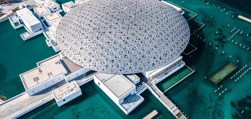 Louvre Abu Dhabi museum dome on Saadiyat Island waterfront beside Sei Saadiyat 2 by Aldar in Saadiyat Cultural District, Abu Dhabi — reference institutional imagery